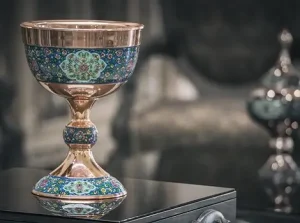 Copper Sangab bowl in Mes Pardaz style on wooden table with candy dish in background